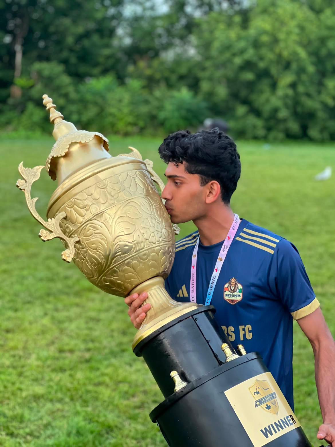 Shamil celebrating with a soccer trophy